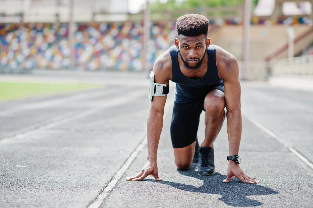athlete sportswear racing alone down running track stadium