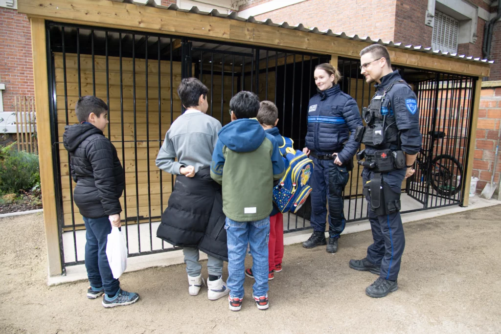 Enfants échangeant avec des policiers municipaux devant un abri sécurisé